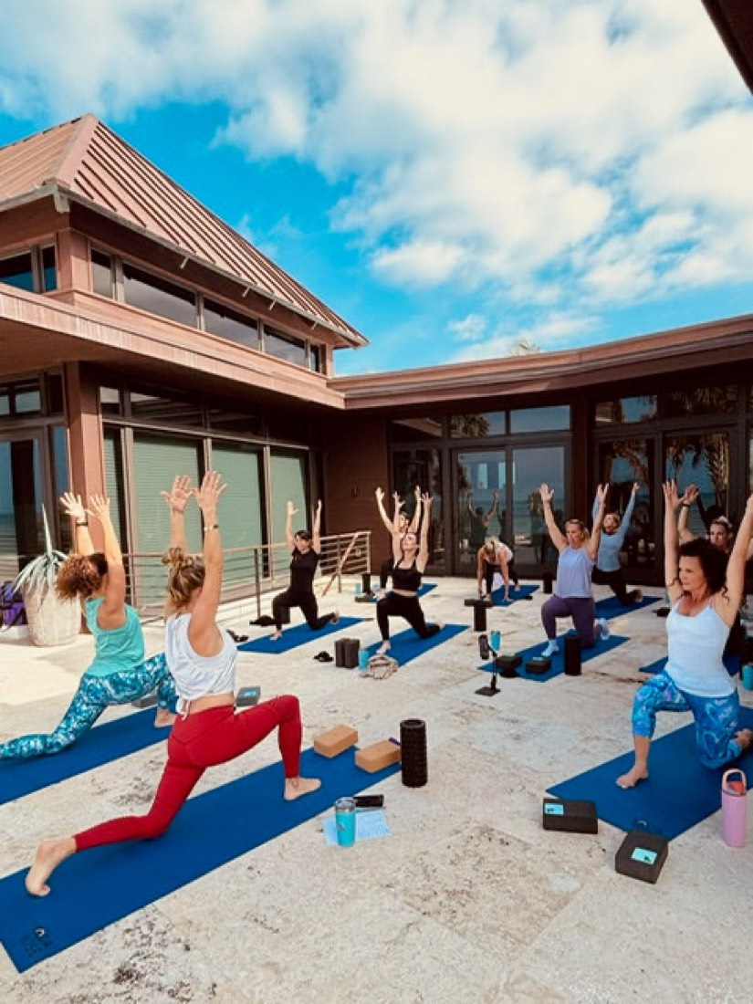 Retreat guests in a yoga session on a coastal terrace